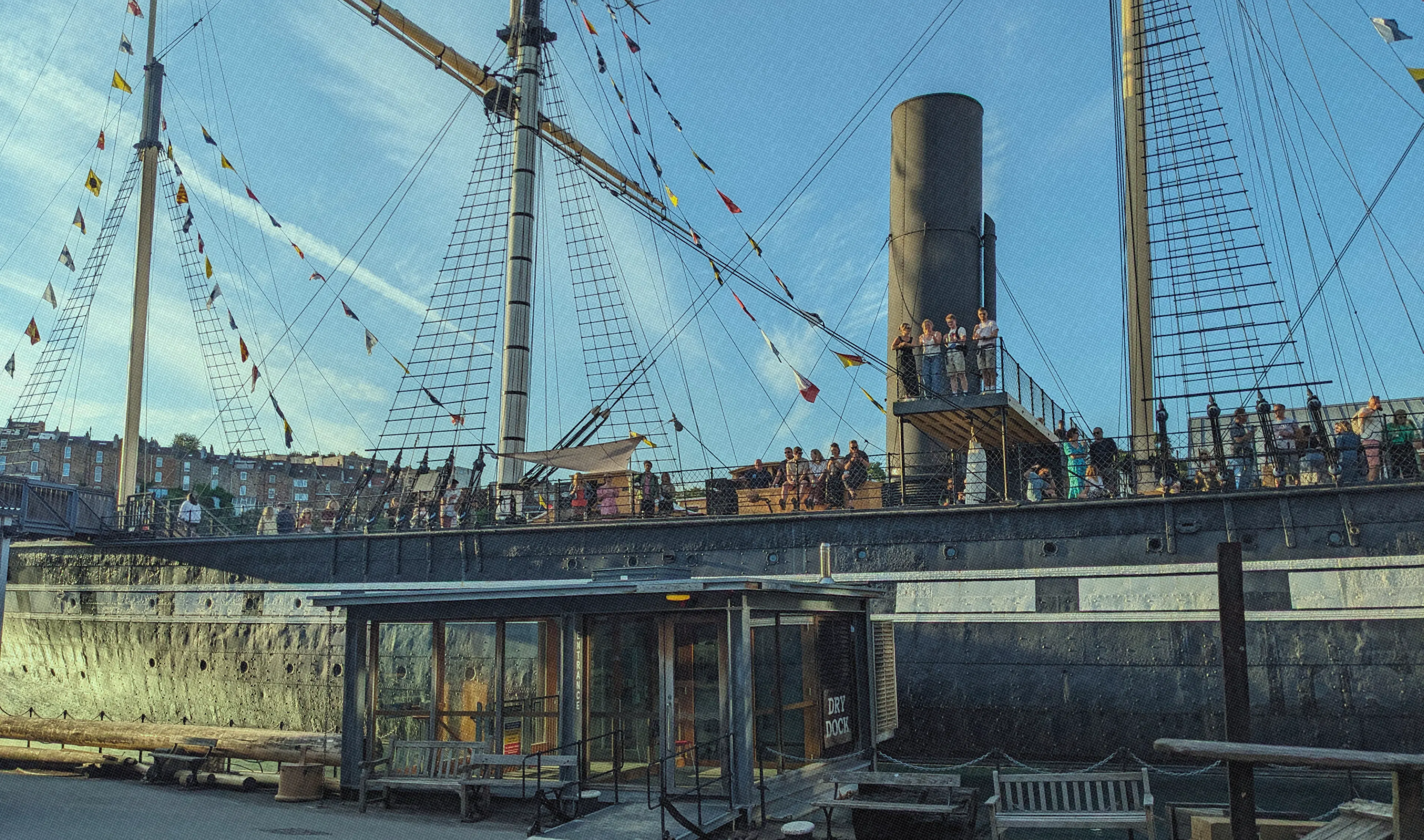 The SS Great Britain sat in Bristol Dockyards with people stood up waving
