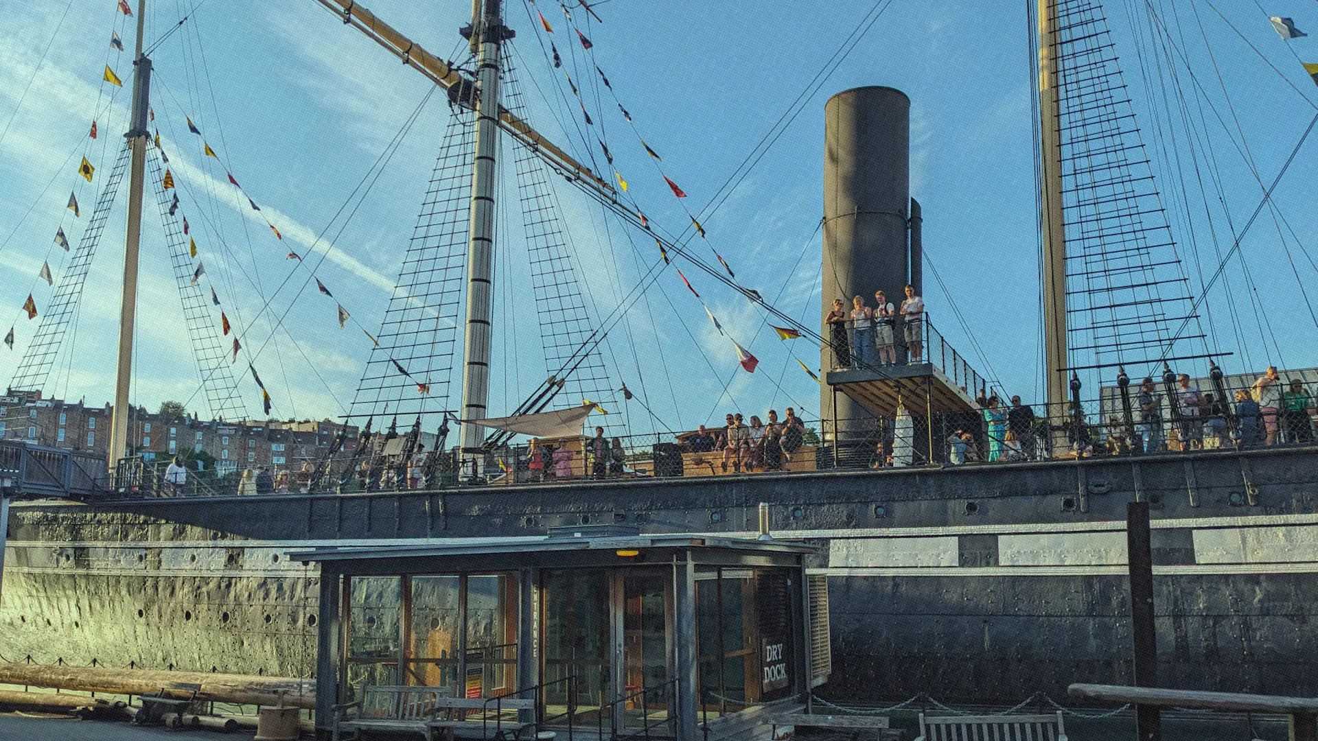 The SS Great Britain sat in Bristol Dockyards with people stood up waving 
