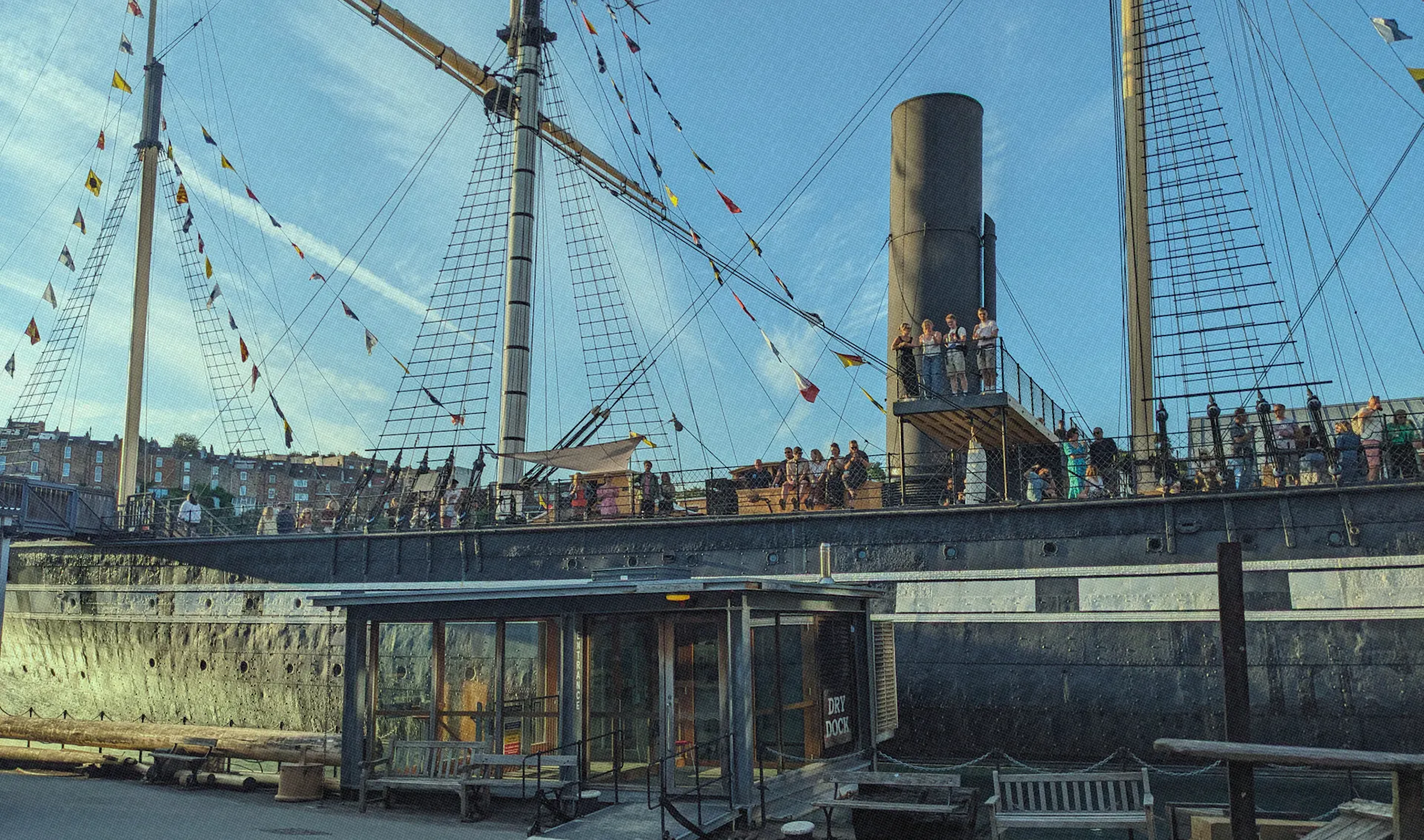 The SS Great Britain sat in Bristol Dockyards with people stood up waving 