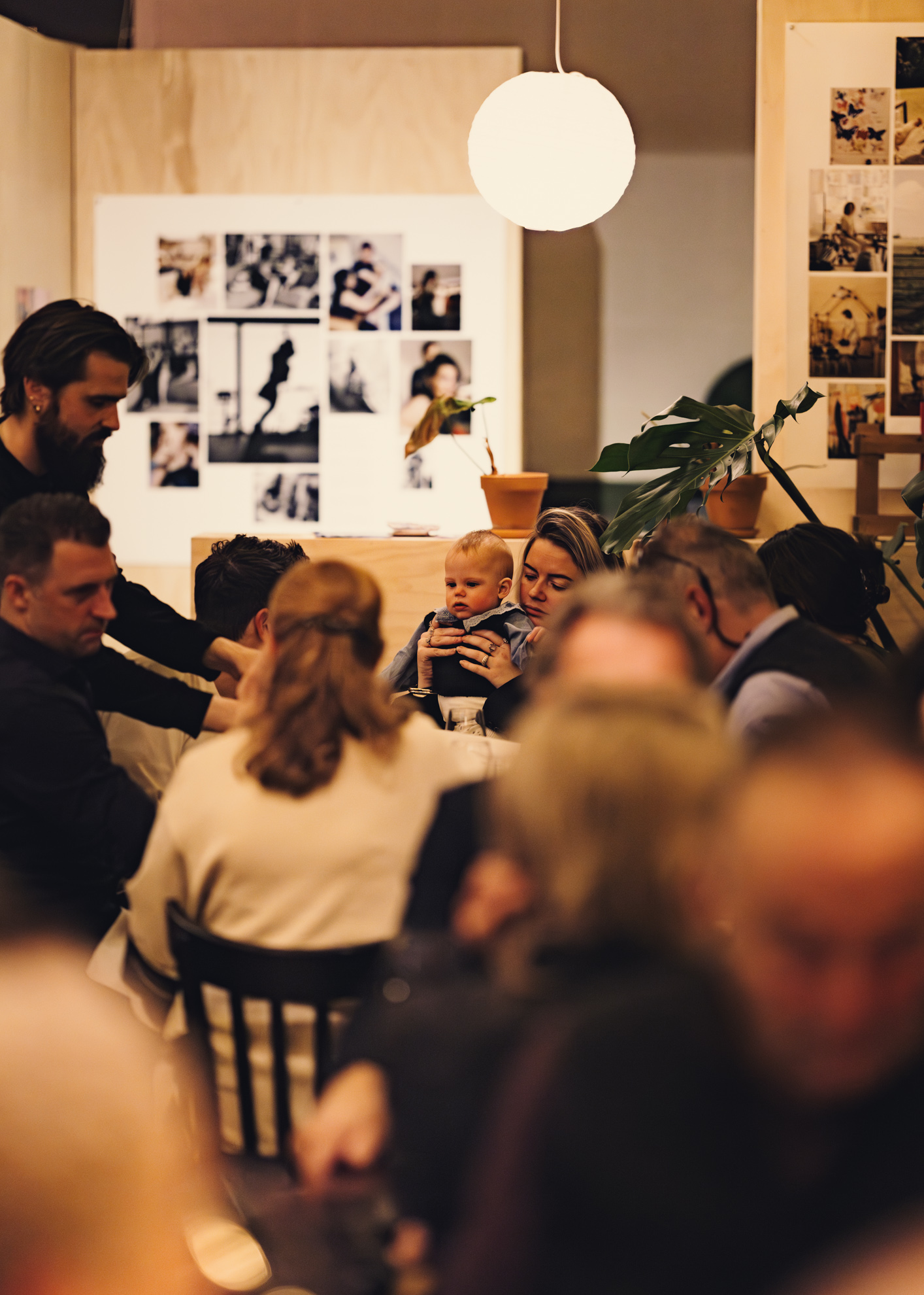 Een ober staat aan tafel bij een familie met een baby in restaurant het broeker huis