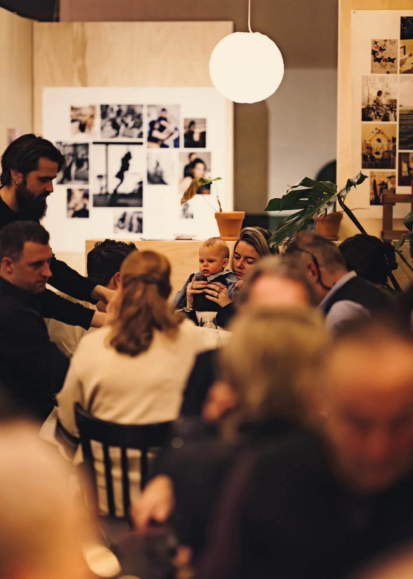 Een ober staat aan tafel bij een familie met een baby in restaurant het broeker huis