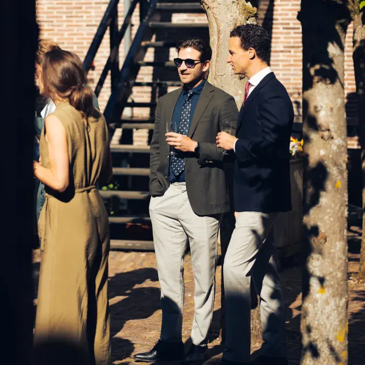 Twee mannen borrelen en praten op de Binnenplaats in de zon