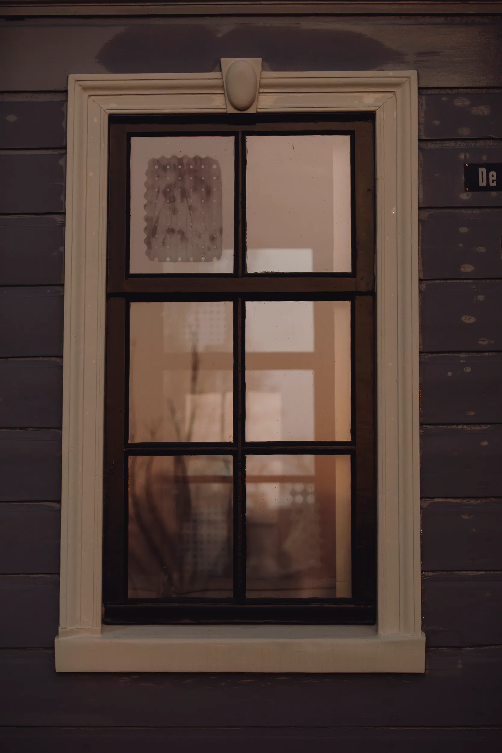 Donkerblauwe houten gevel wit kozijn raam