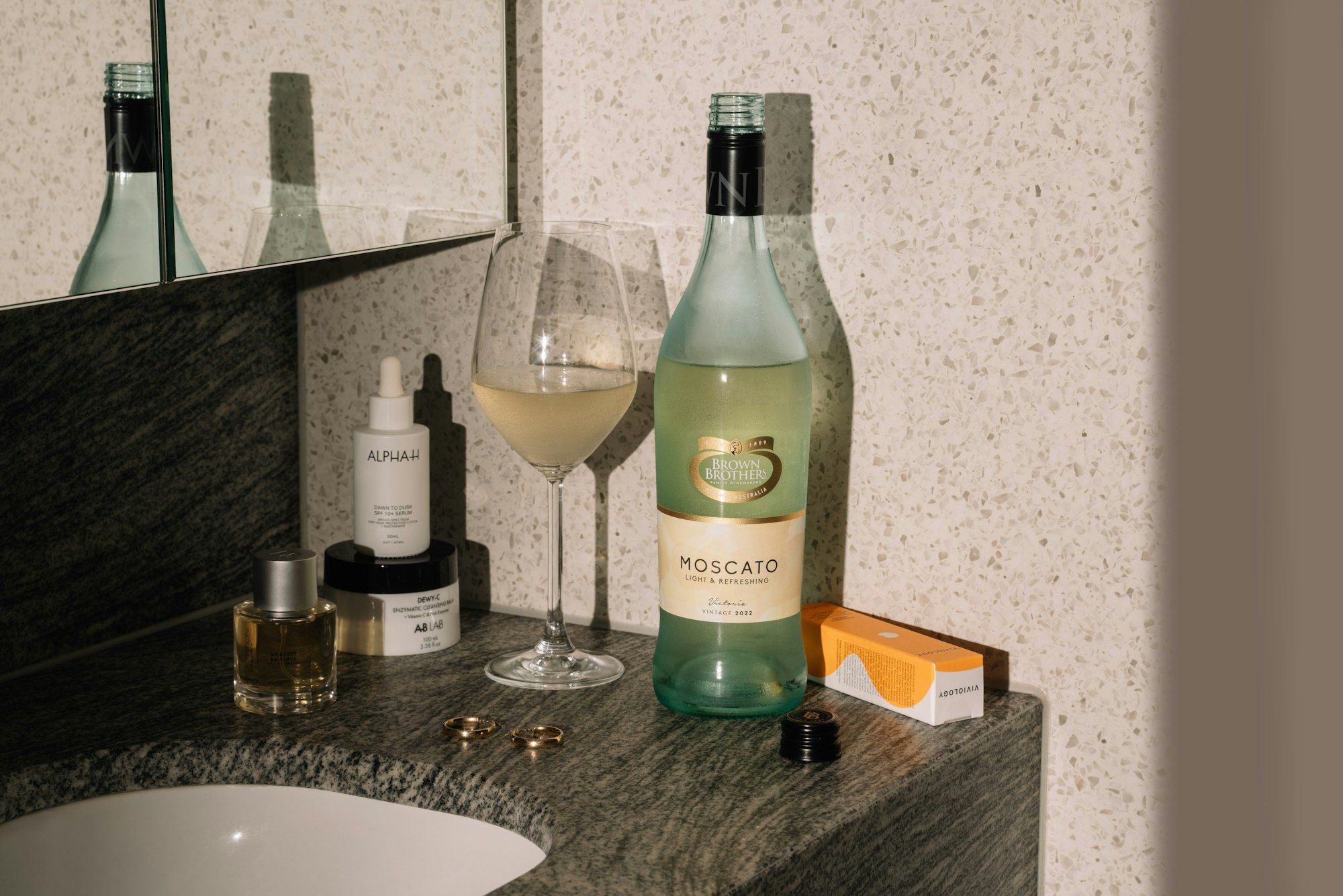 Adore Beauty products and Brown Brothers Moscato on bathroom vanity
