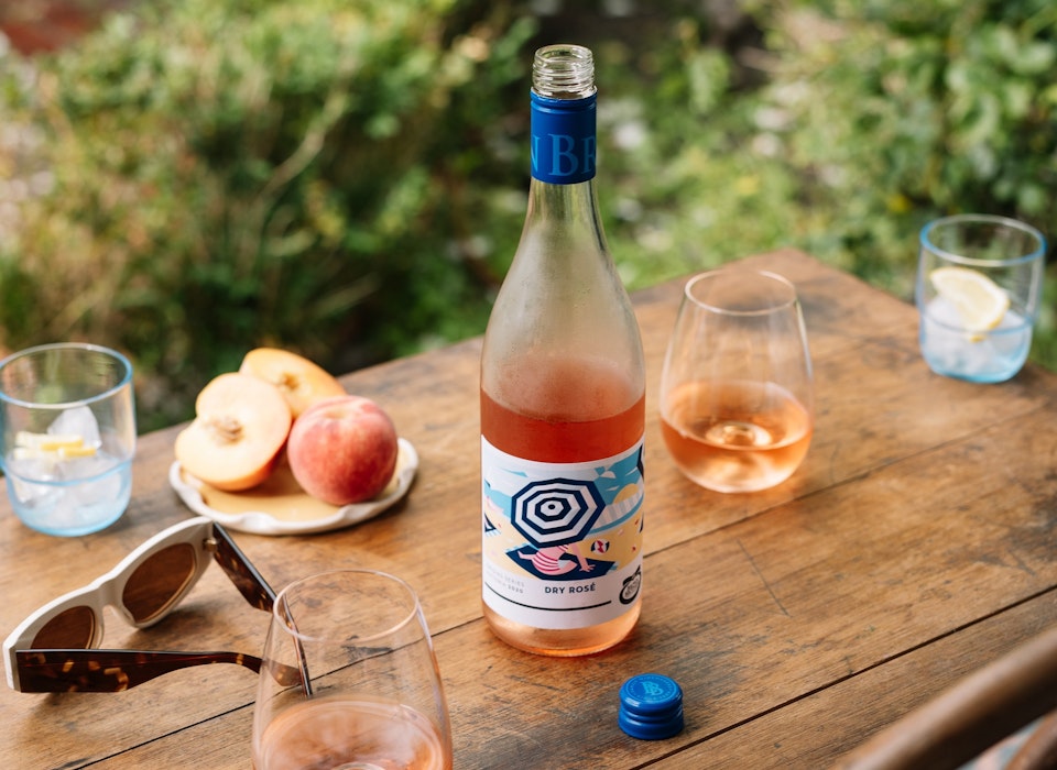 bottle of Origins Series Rose and fresh fruit outdoors