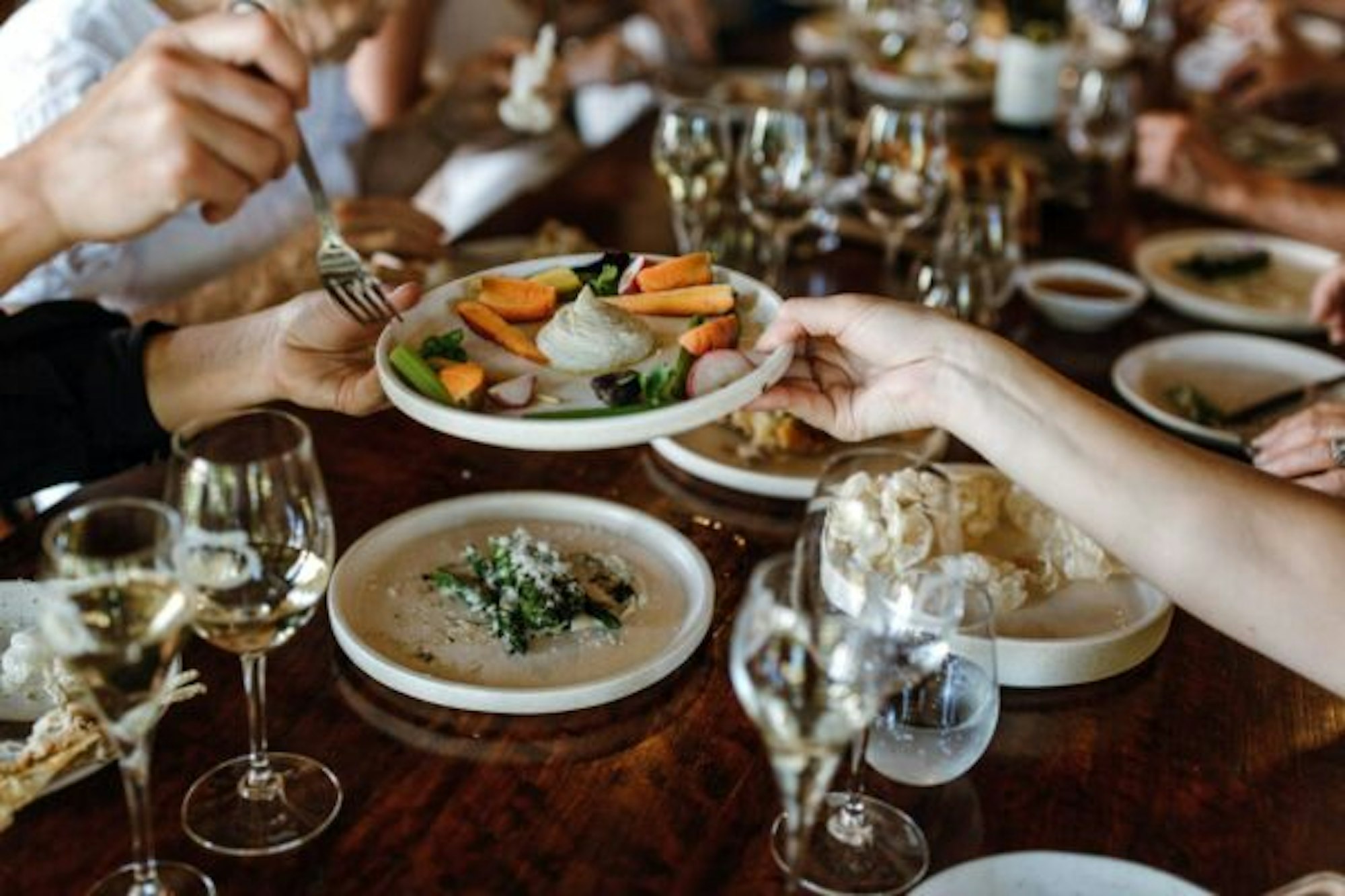 Restaurant dish being passed to another person