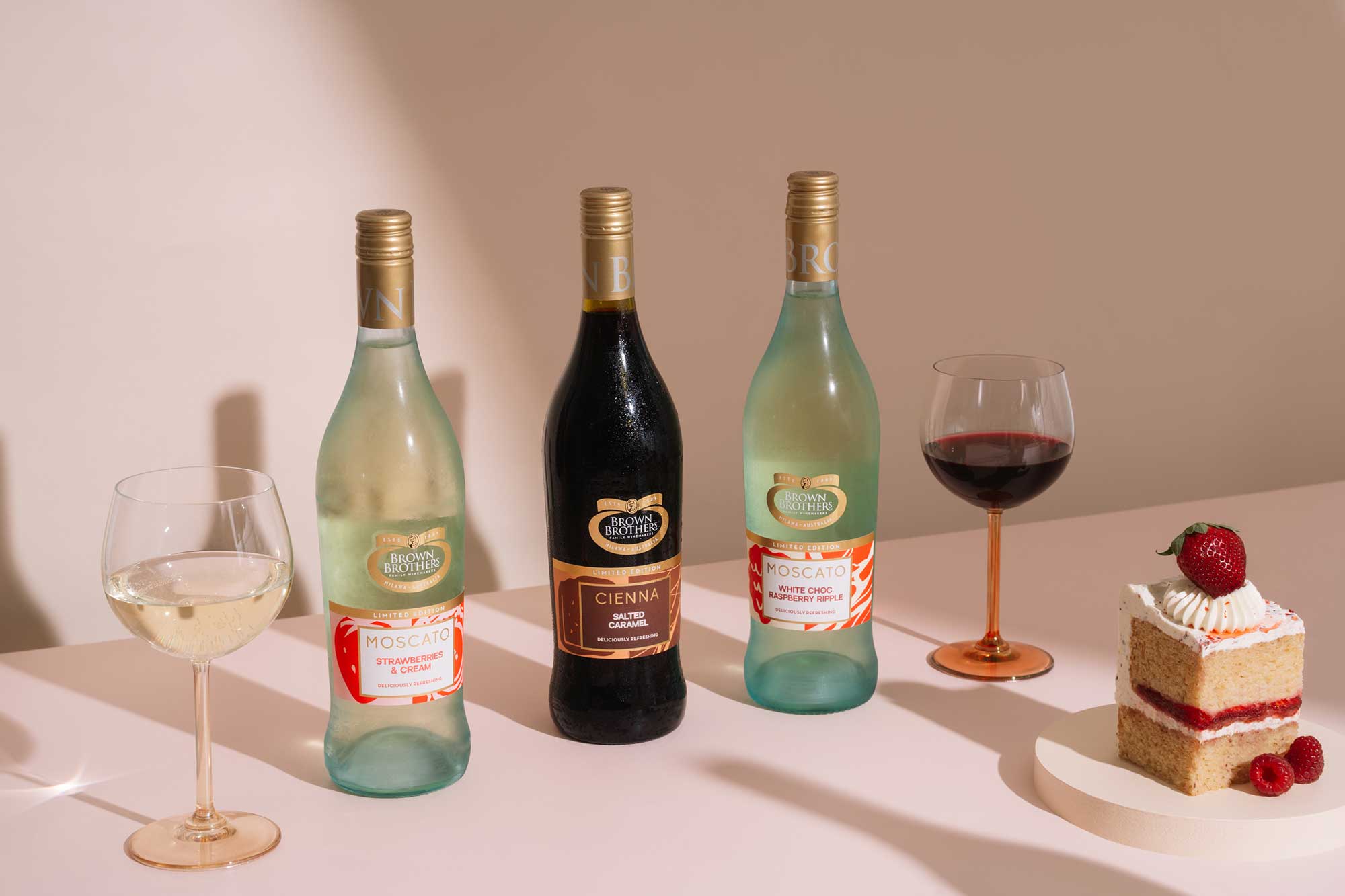 Limited Edition Moscato Strawberries & Cream, Cienna Salted Caramel, Moscato White Choc Ripple, among two glasses of wine and strawberry cake