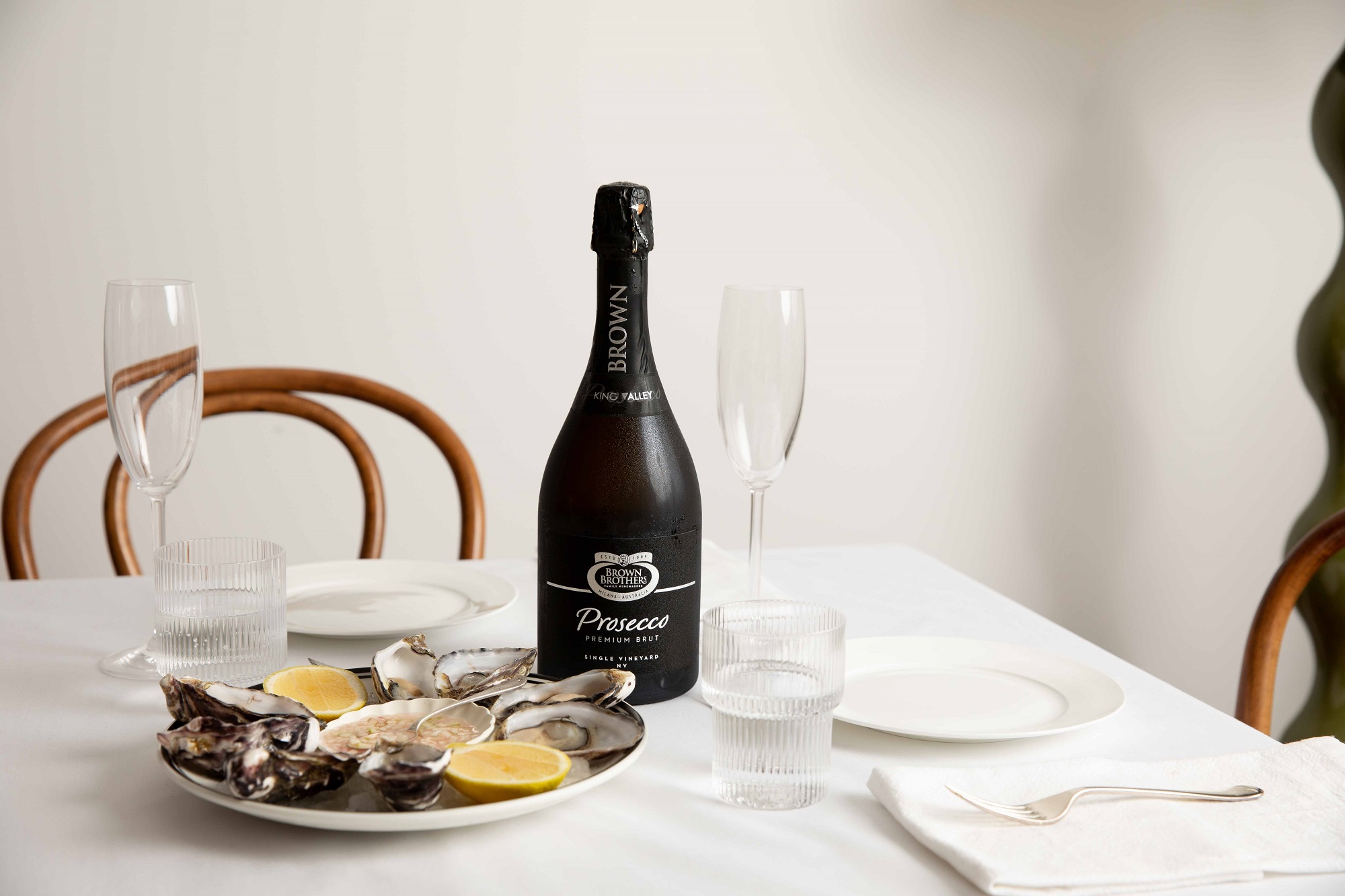 bottle of prosecco premium brut on a table set with oysters