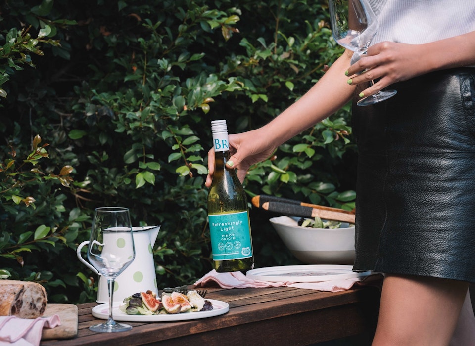 Brown Brothers Refreshingly Light Pinot Grigio; brought to an outdoor table set with food