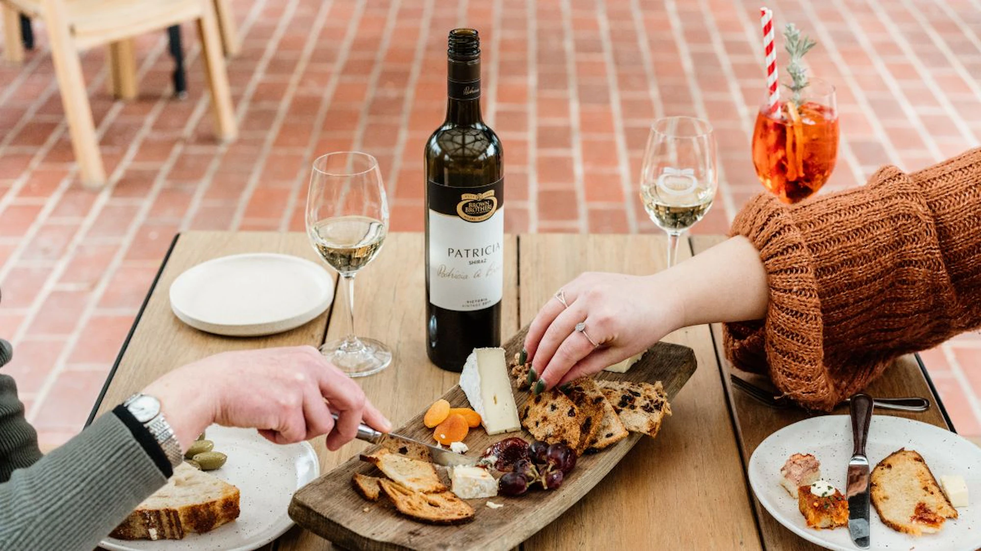 A bottle of Brown Brothers Patricia with a cheese board