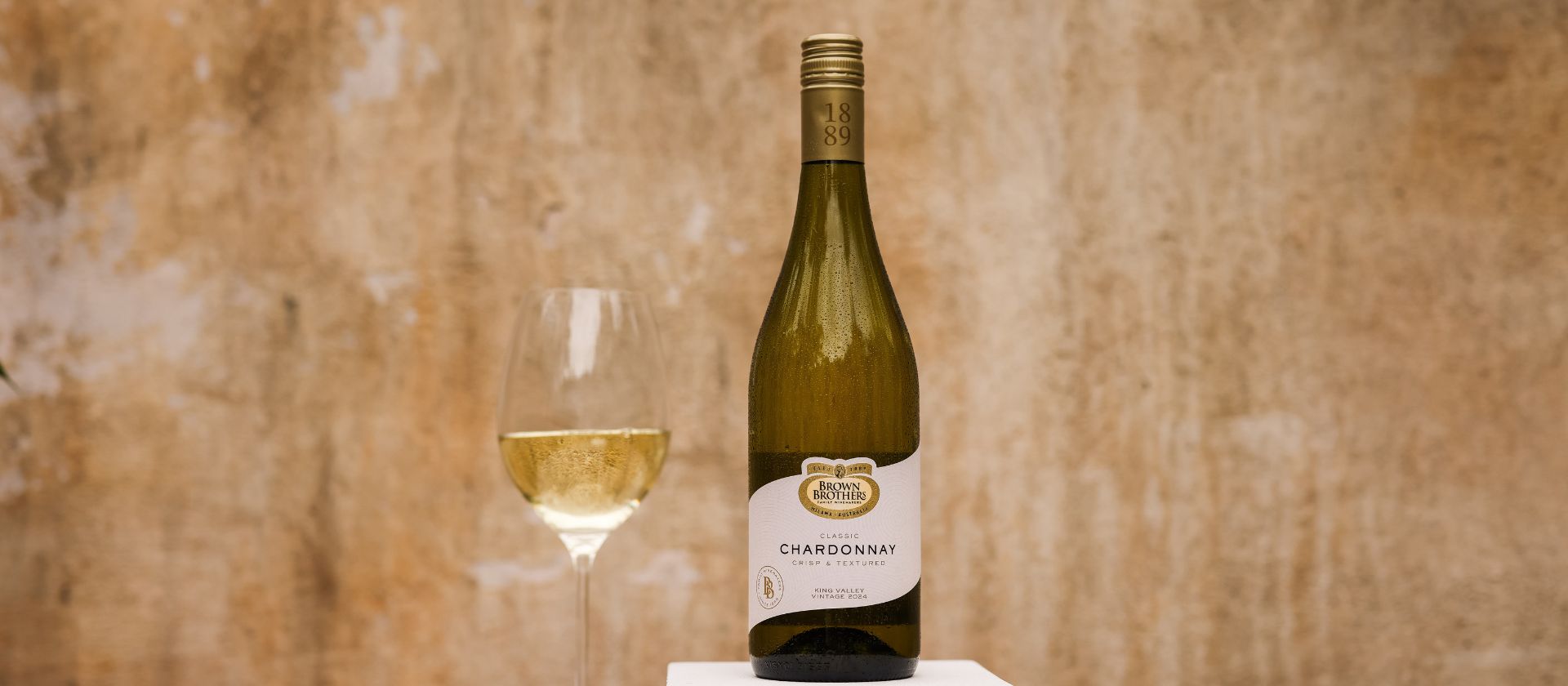 A bottle of Brown Brothers Chardonnay with a glass of wine