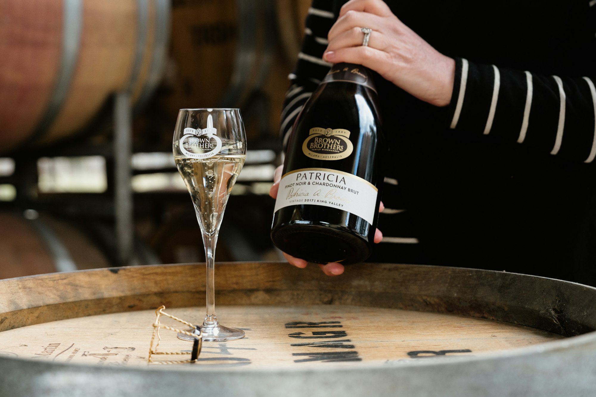 Winemaker Cate Looney holding a bottle of Patricia Sparkling