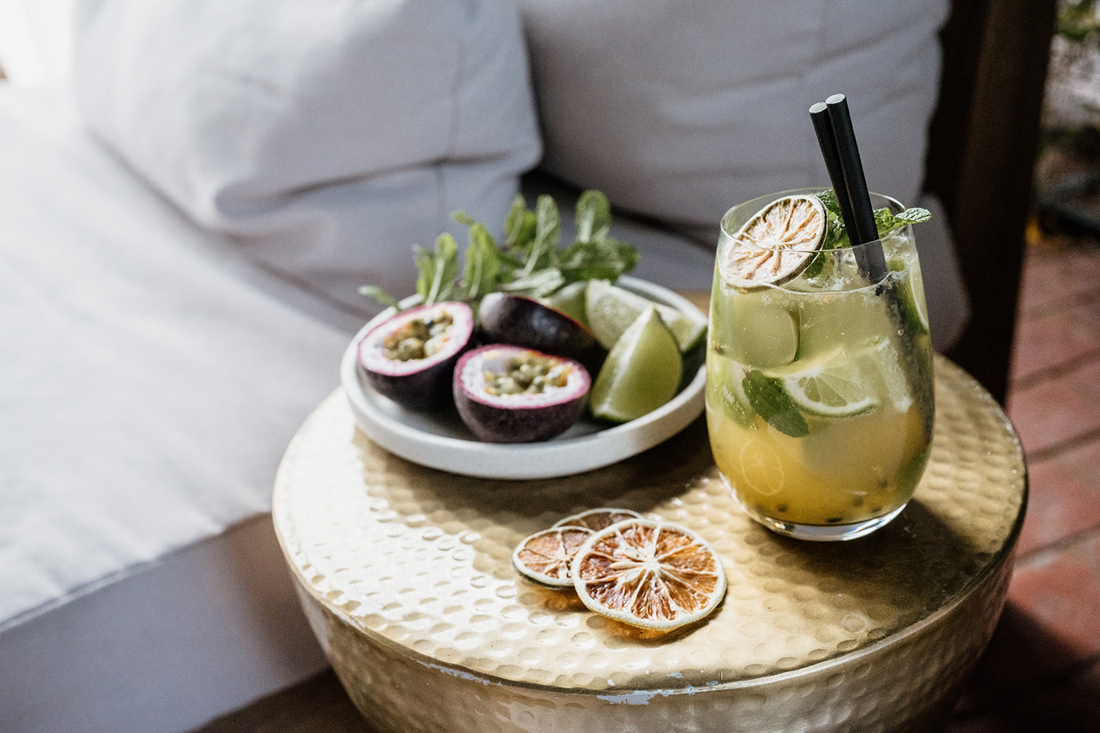 Passionfruit Mojito in a glass next to a bowl of fresh passionfruit