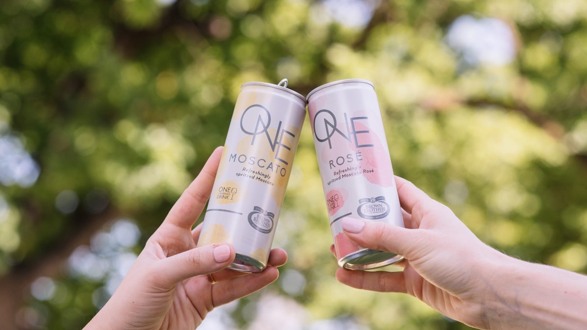 Two hands holding Moscato One Cans