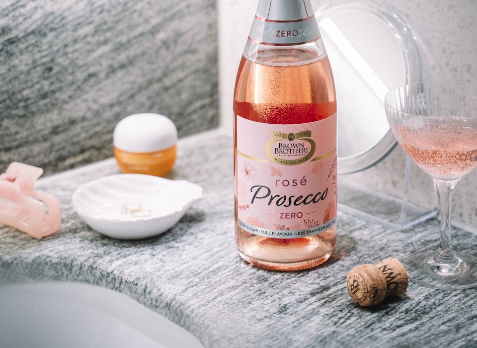 Brown Brothers Prosecco Rose Zero bottle and glass, on a bathroom vanity