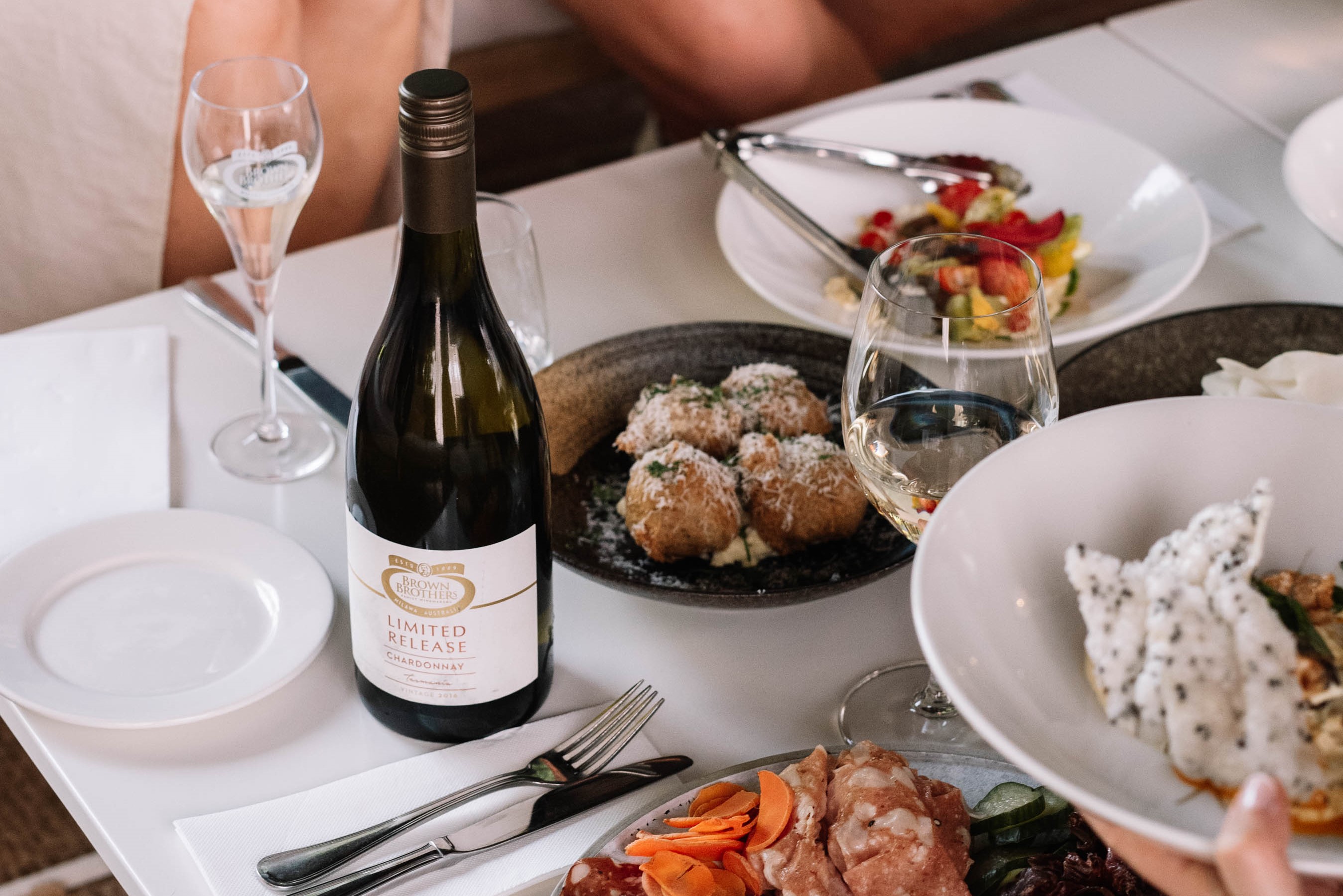 Bottle of wine and food on table in Prosecco Lounge