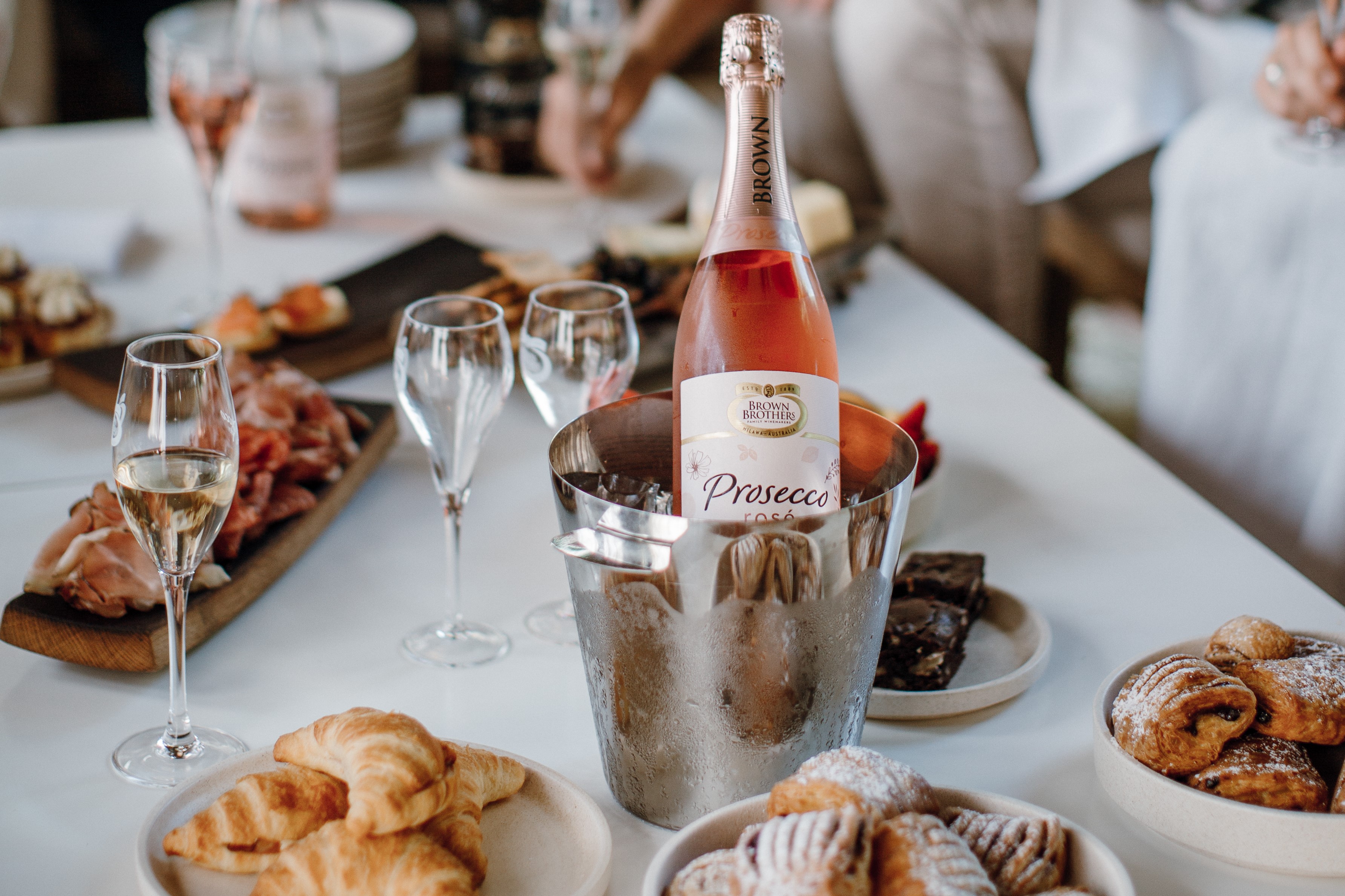 Bottle of Prosecco Rose in ice bucket with brunch food on table
