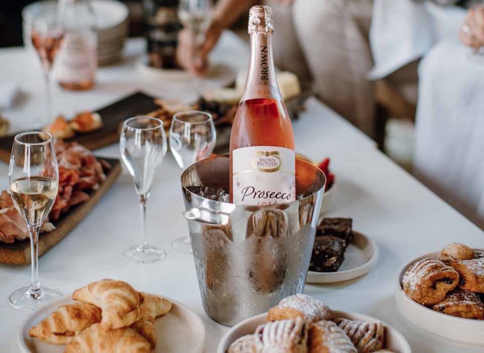 Bottle of Prosecco Rose in ice bucket with brunch food on table