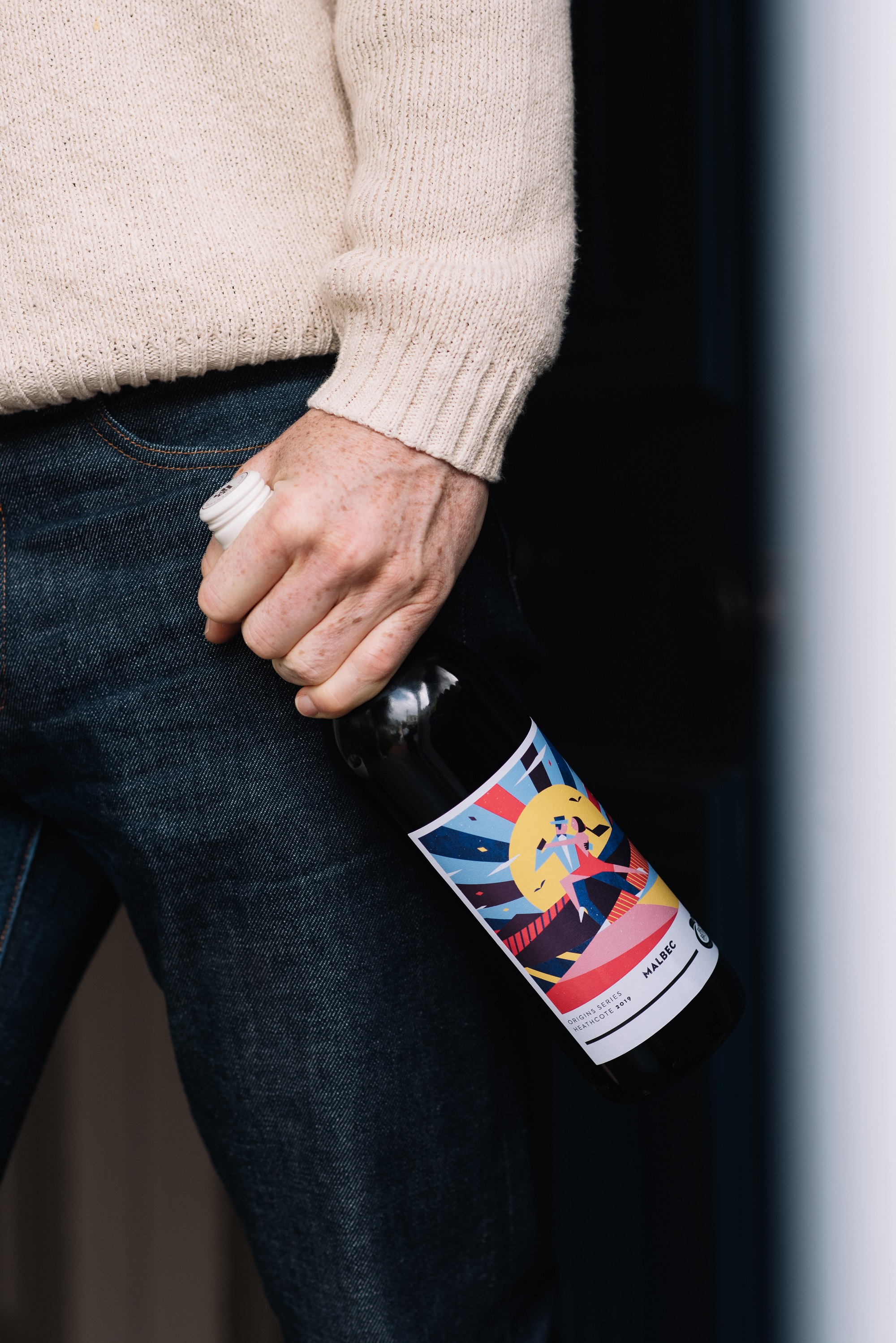 closeup shot of man holding a bottle of Origins Series Malbec