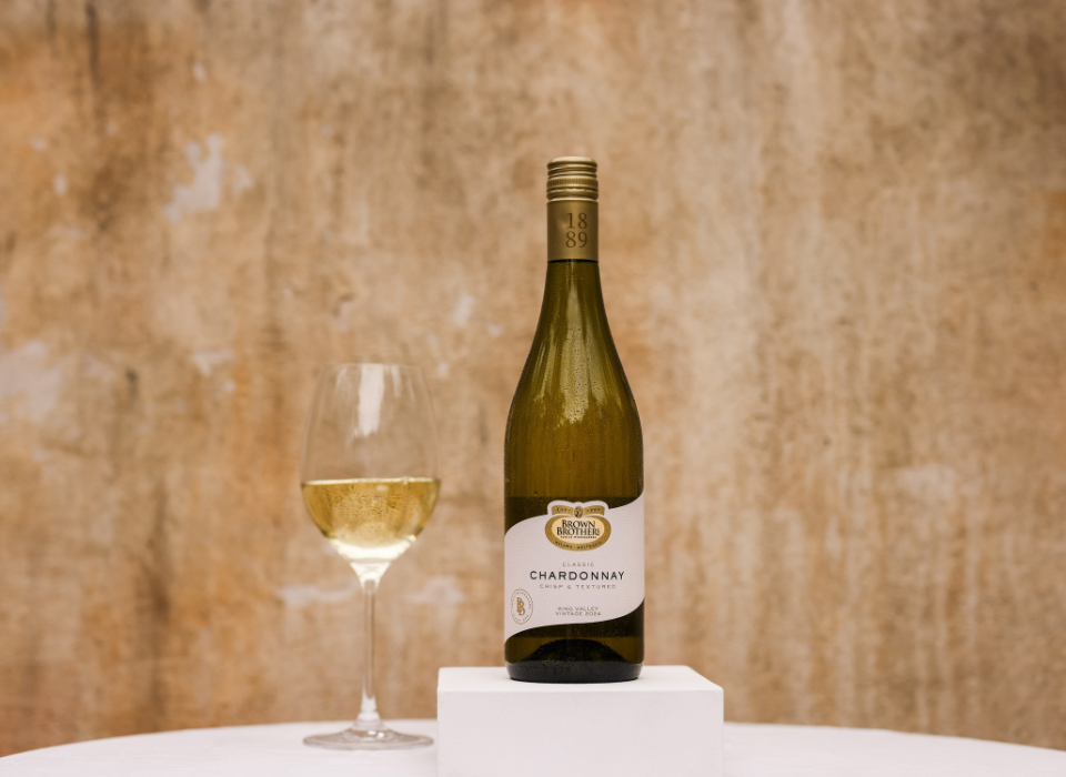 A bottle of Brown Brothers Classic Chardonnay with a wine glass