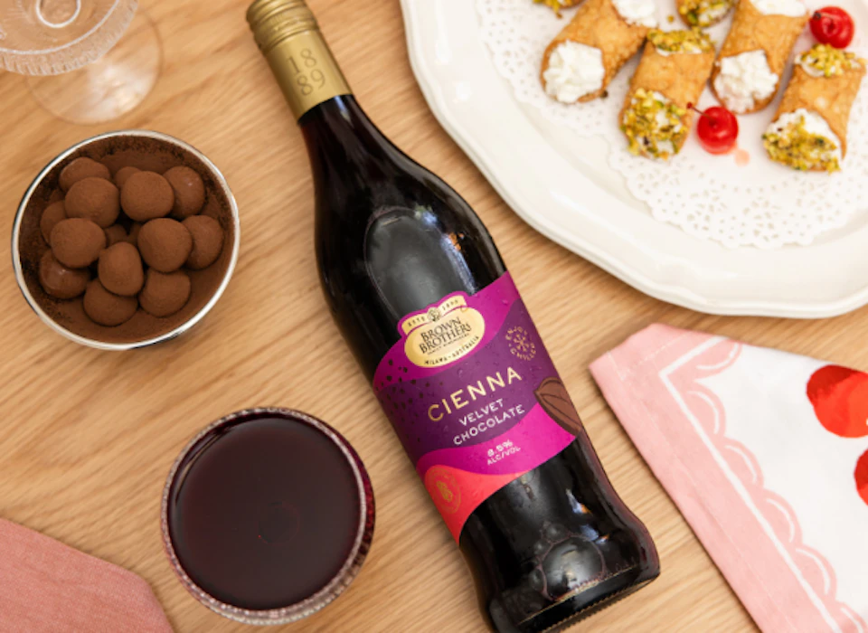 A flatlay of Brown Brothers Cienna Velvet with chocolates and cannoli