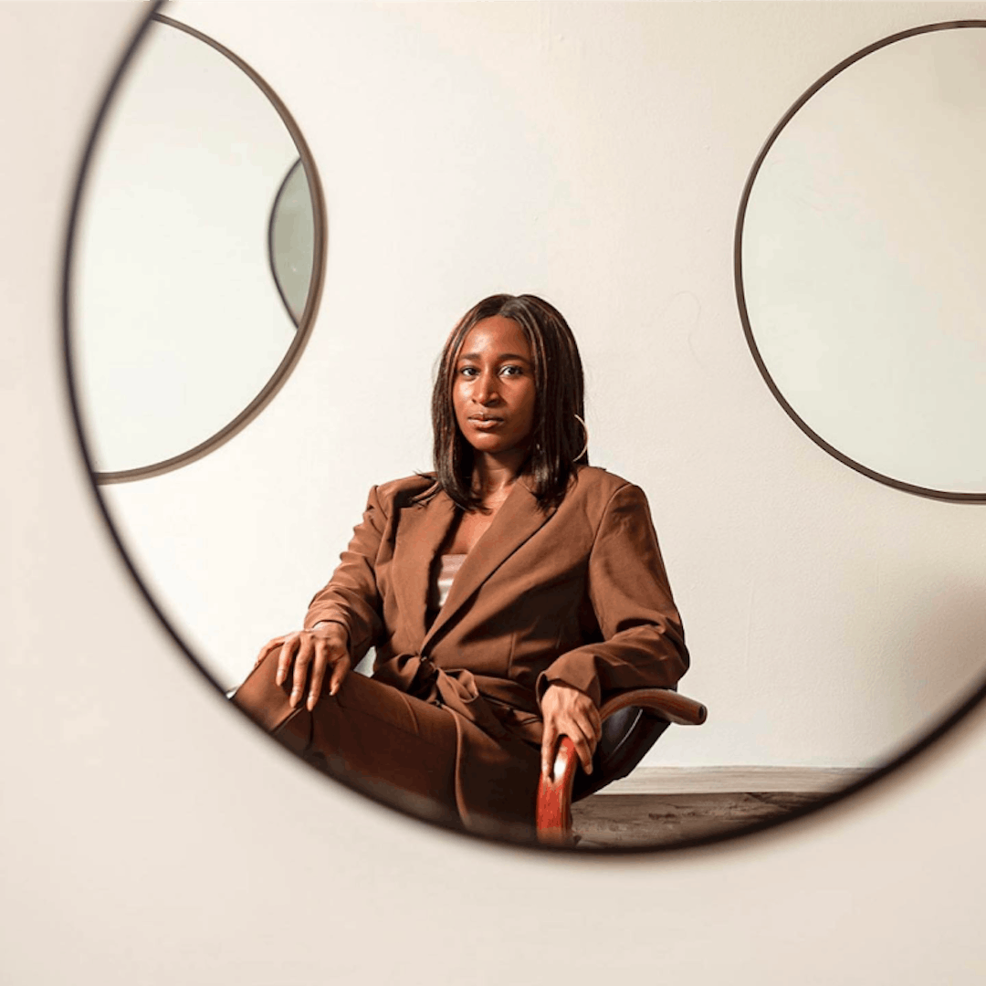 CherRaye the founder sitting in a chair. Portrait photo.