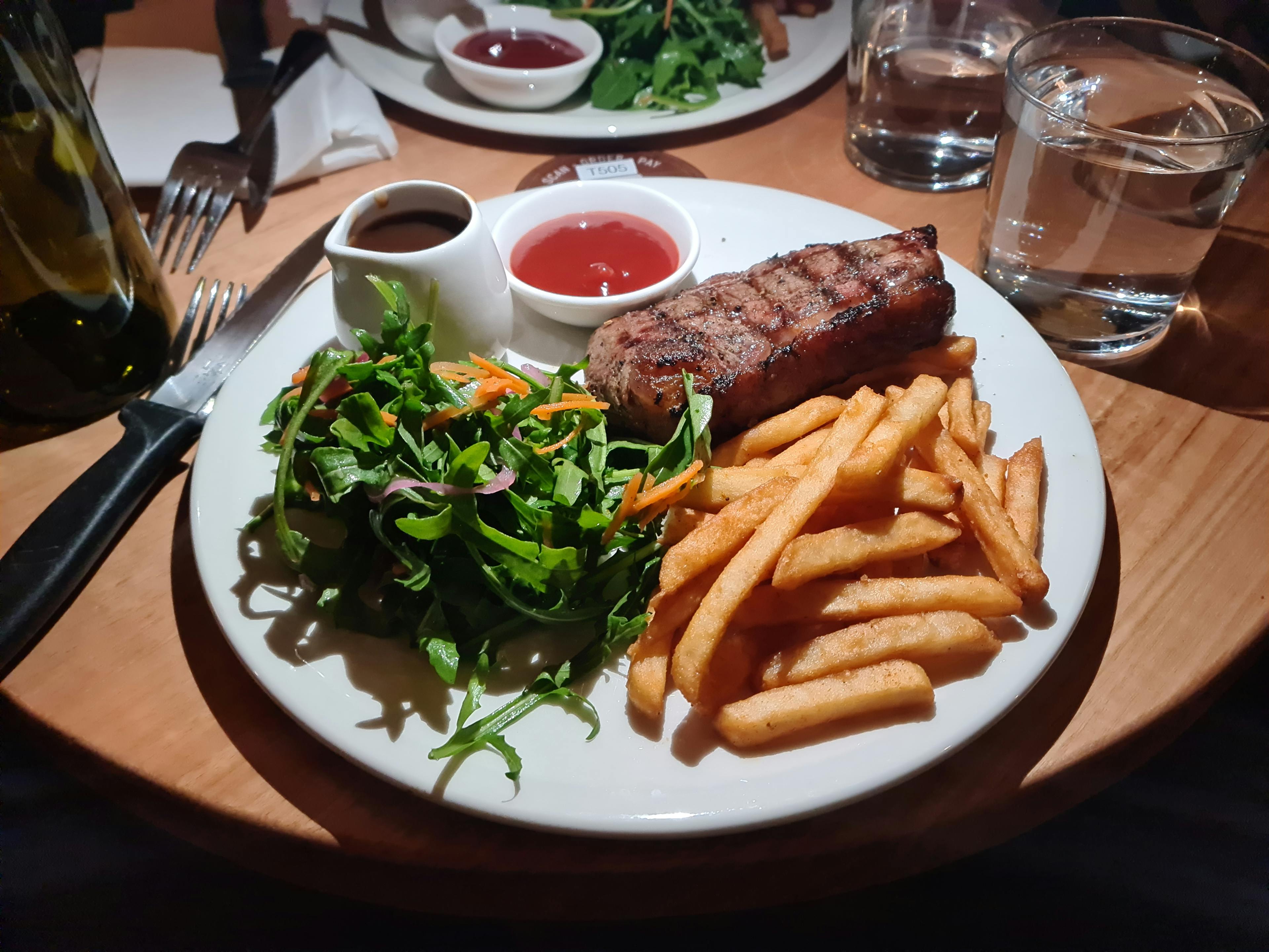 Sirloin steak served with fries, salad, gravy and tomato sauce