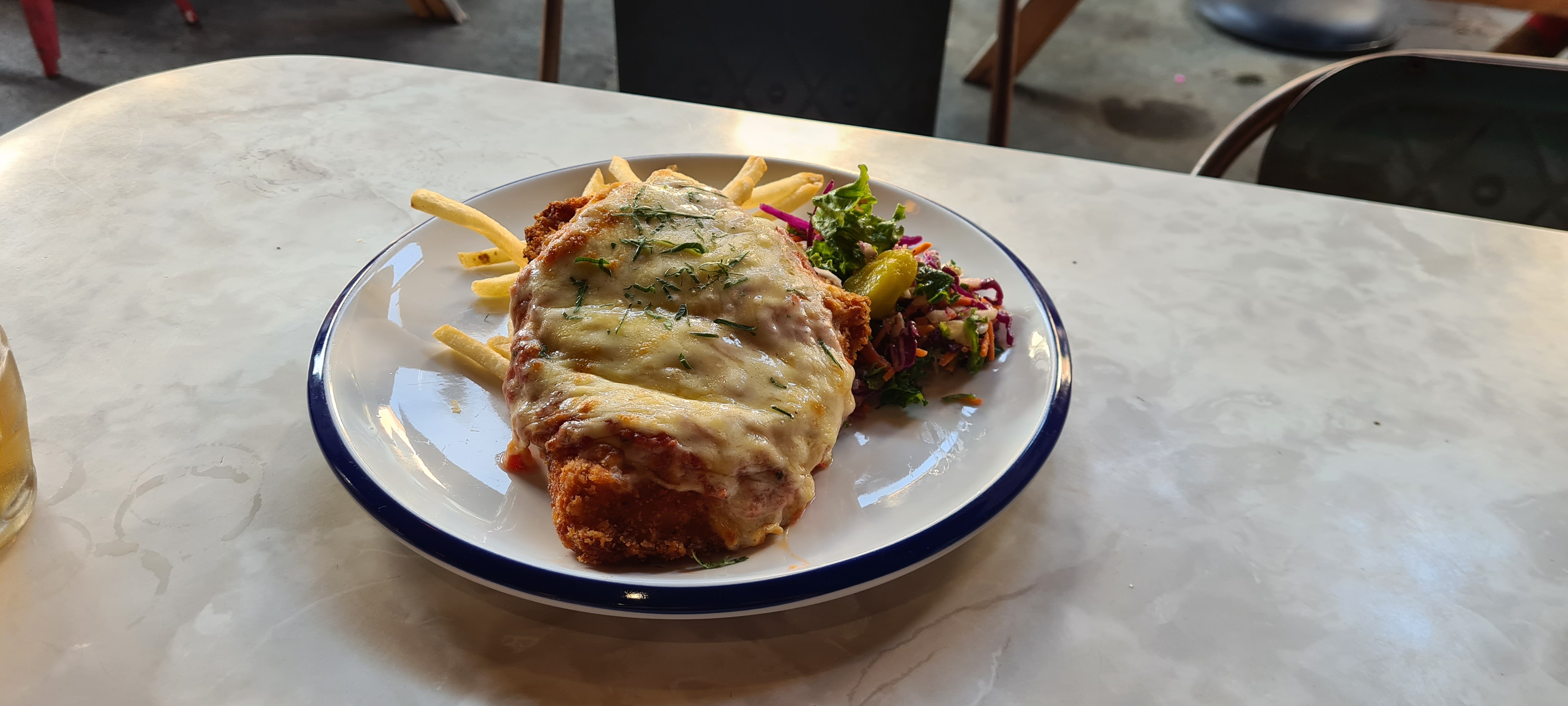 Slab of crumbed, fried chicken, covered in marinara sauce and melted cheese