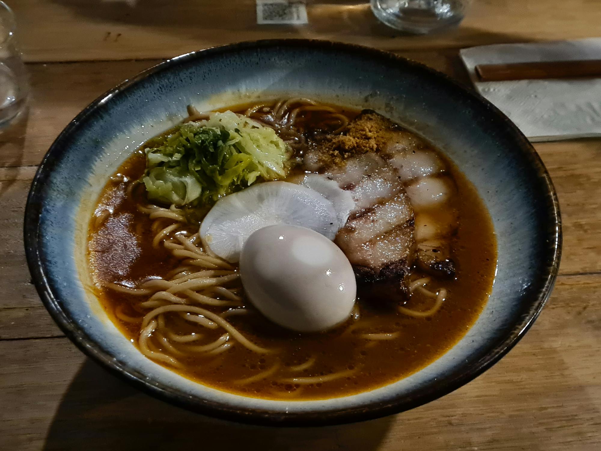 Ramen bowl with a soft boiled egg sitting on top of chashu pork