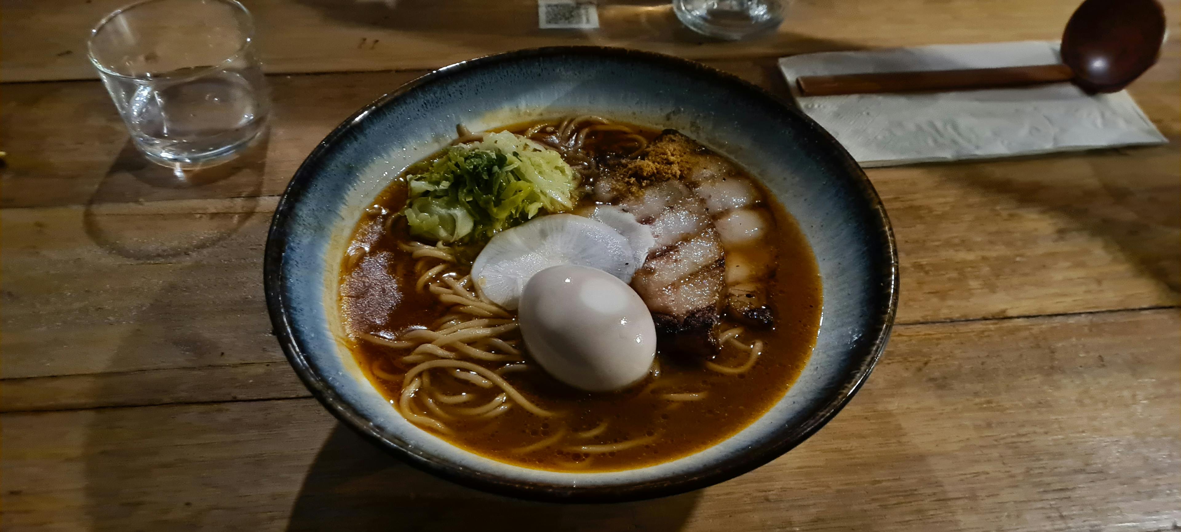 Ramen bowl with a soft boiled egg sitting on top of chashu pork