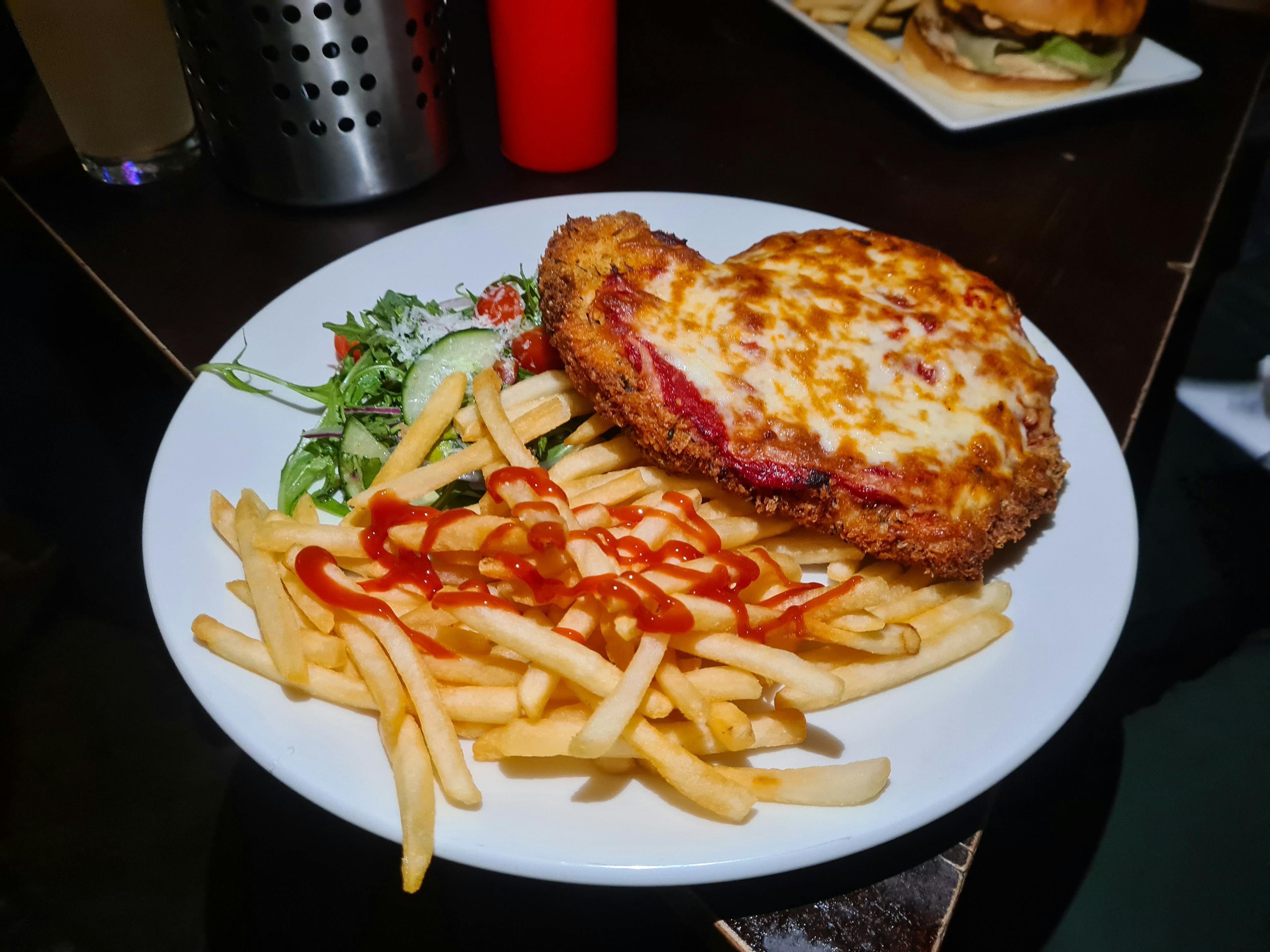 Chicken parma with a mountain of fries and a simple iceberg lettuce salad