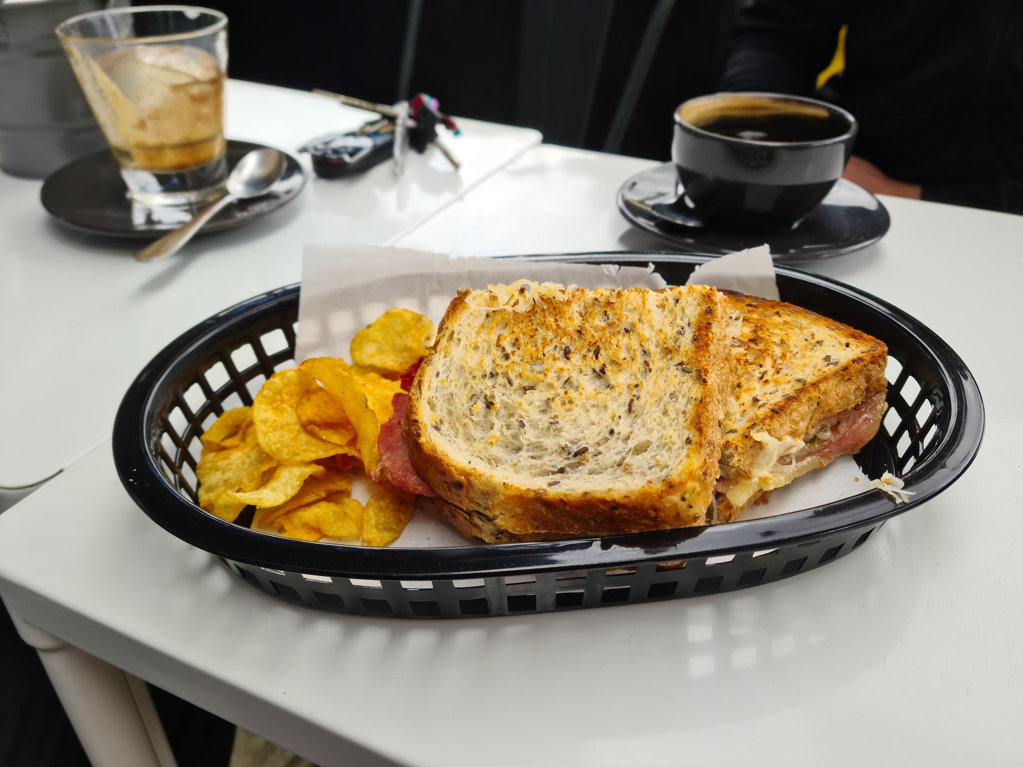 Multigrain sandwich served with a side of crisps