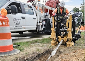 Underground telecommunications crew installing conduit and fiber infrastructure.