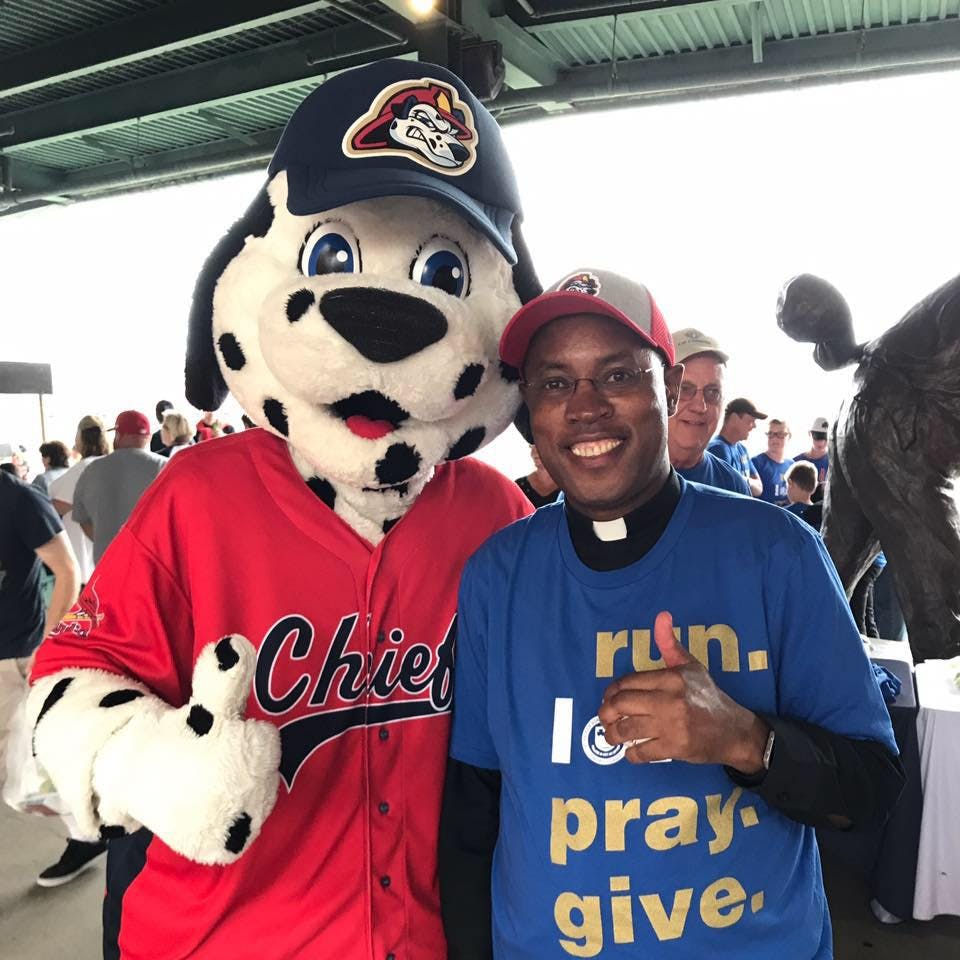 Fr. Julius with Homer, the Chiefs mascot, at the August 26, 2017 ballgame in Peoria, IL. 