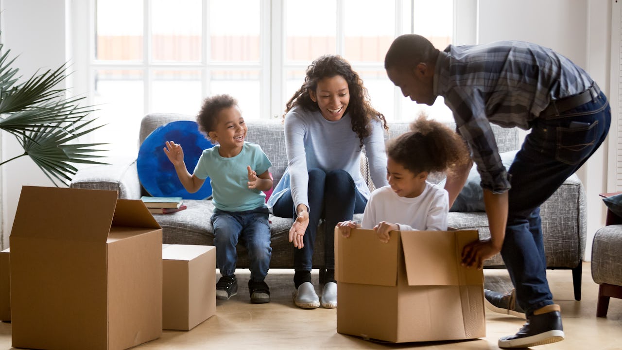 Happy playful large African American family moving in new apartment