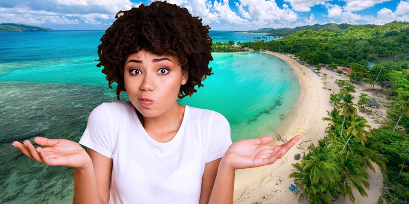 Woman with her hands up in the air and beach in the background