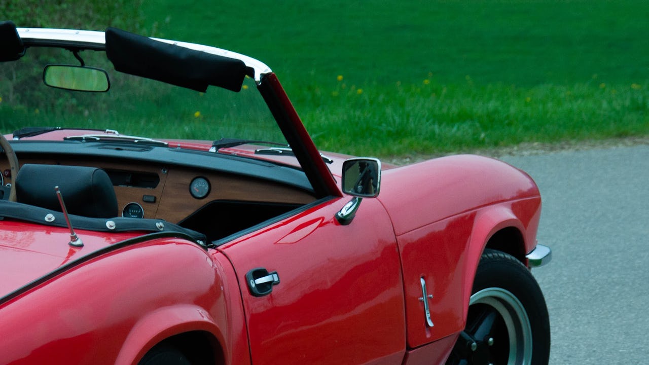 A red convertible stop on the road