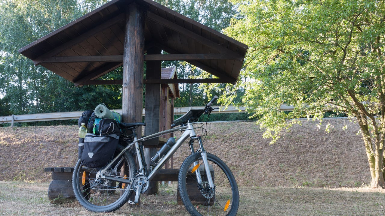 Mountain bike with camping gear and saddlebags mounted on the bike.