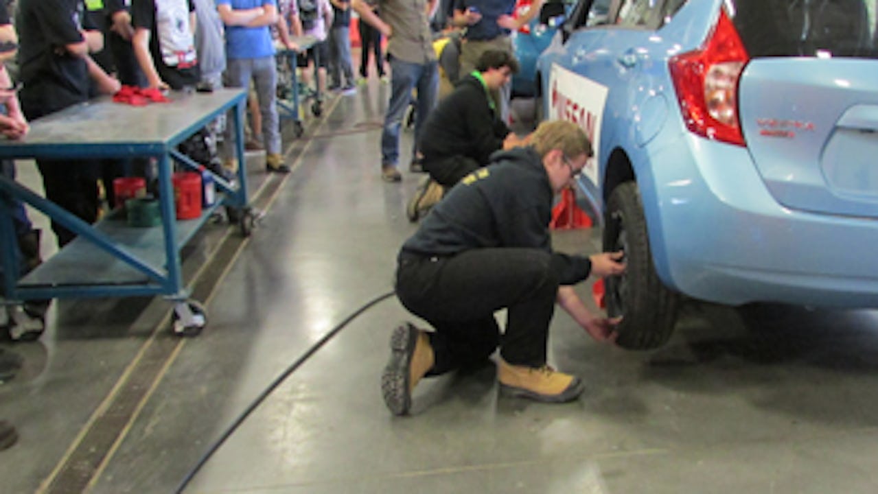Students working on changing tires in an auto class