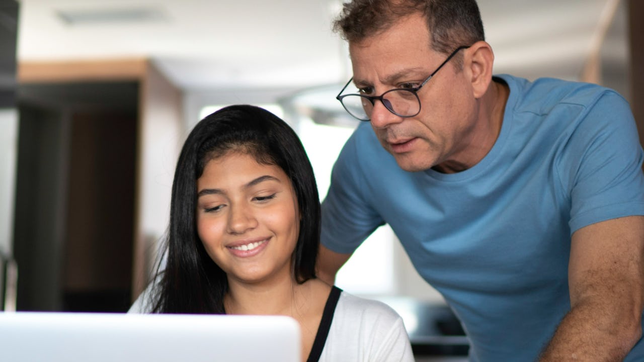 Father helping daughter on a computer