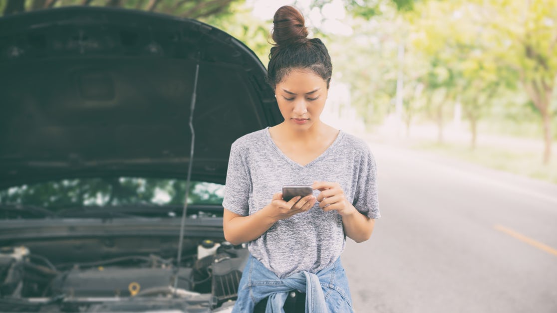 Young woman on phone with car breakdown