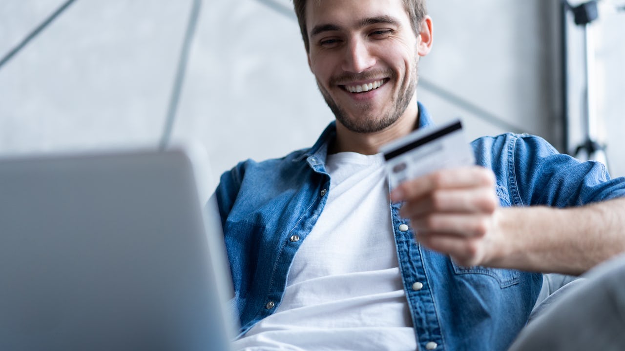 Man holding credit card and using a laptop