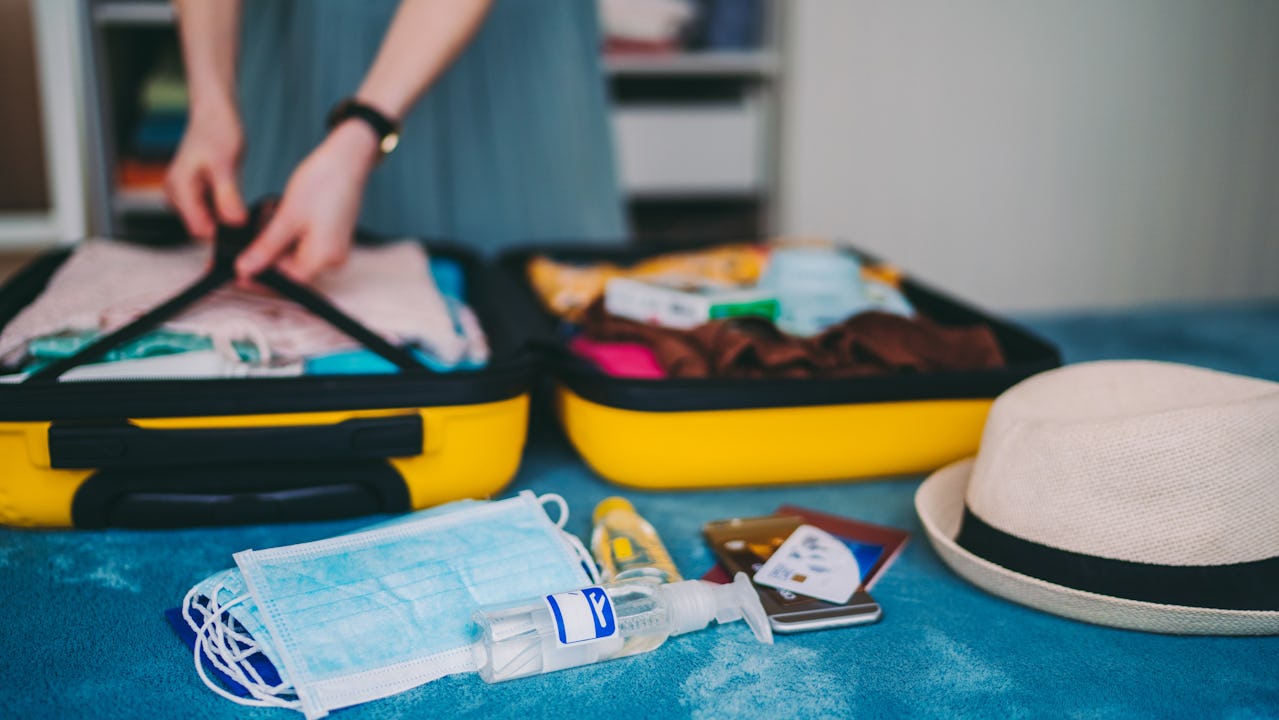 Packing luggage with face mask and hand sanitizer 