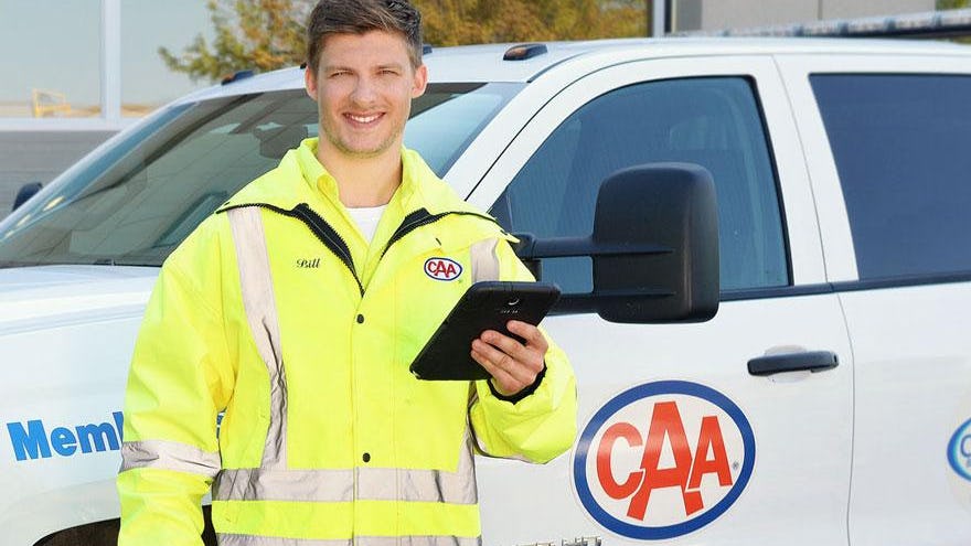 Smiling CAA employee in front of a CAA truck