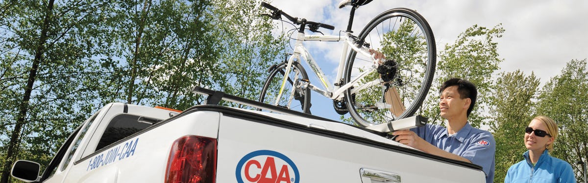 CAA roadside technician loading a bicycle onto a CAA light service truck