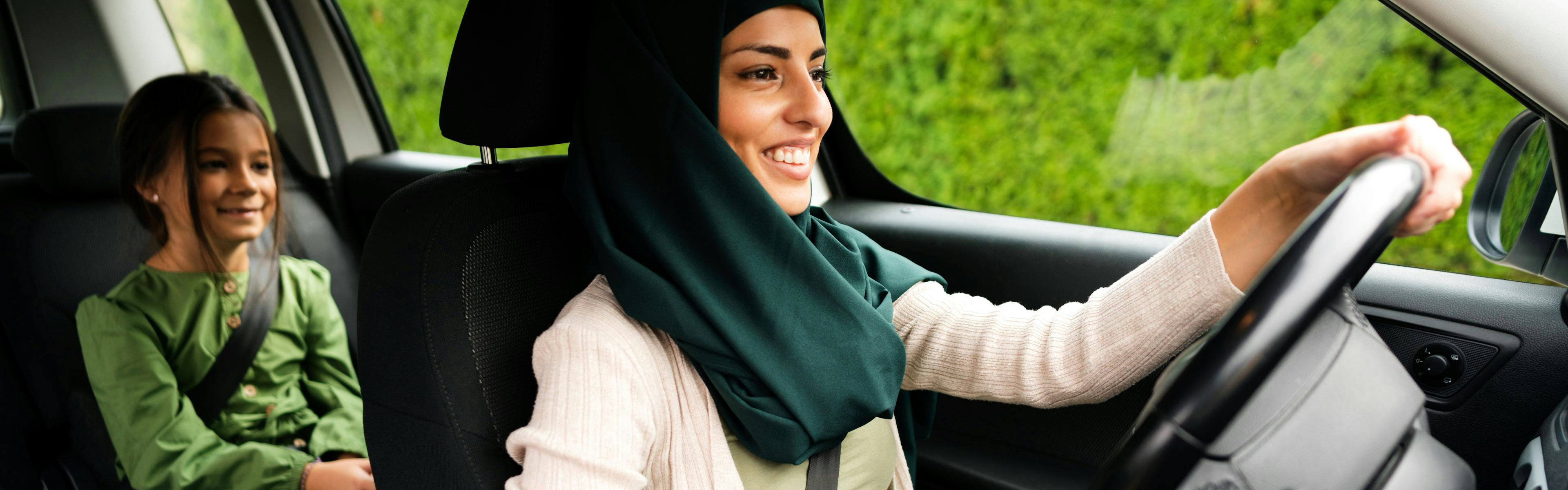 A muslim woman is driving car with her daughter