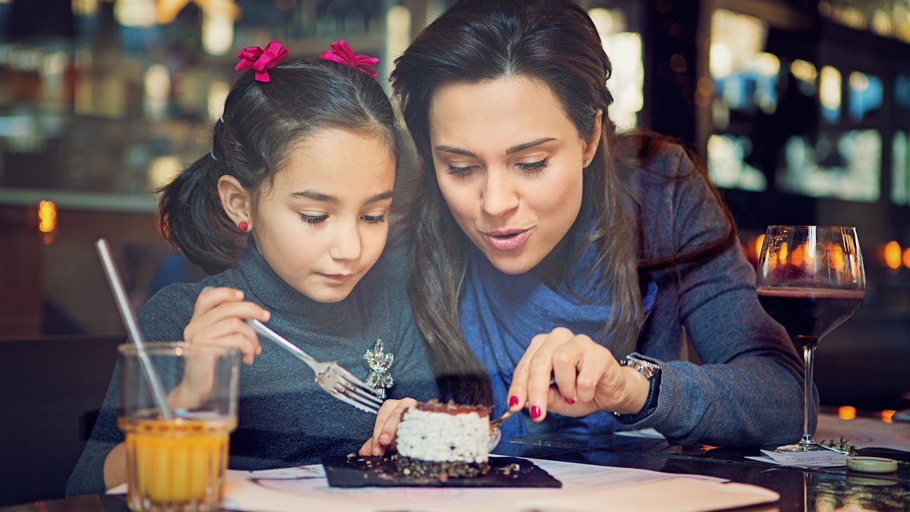 A mother and daughter sharing desert at a restaurant