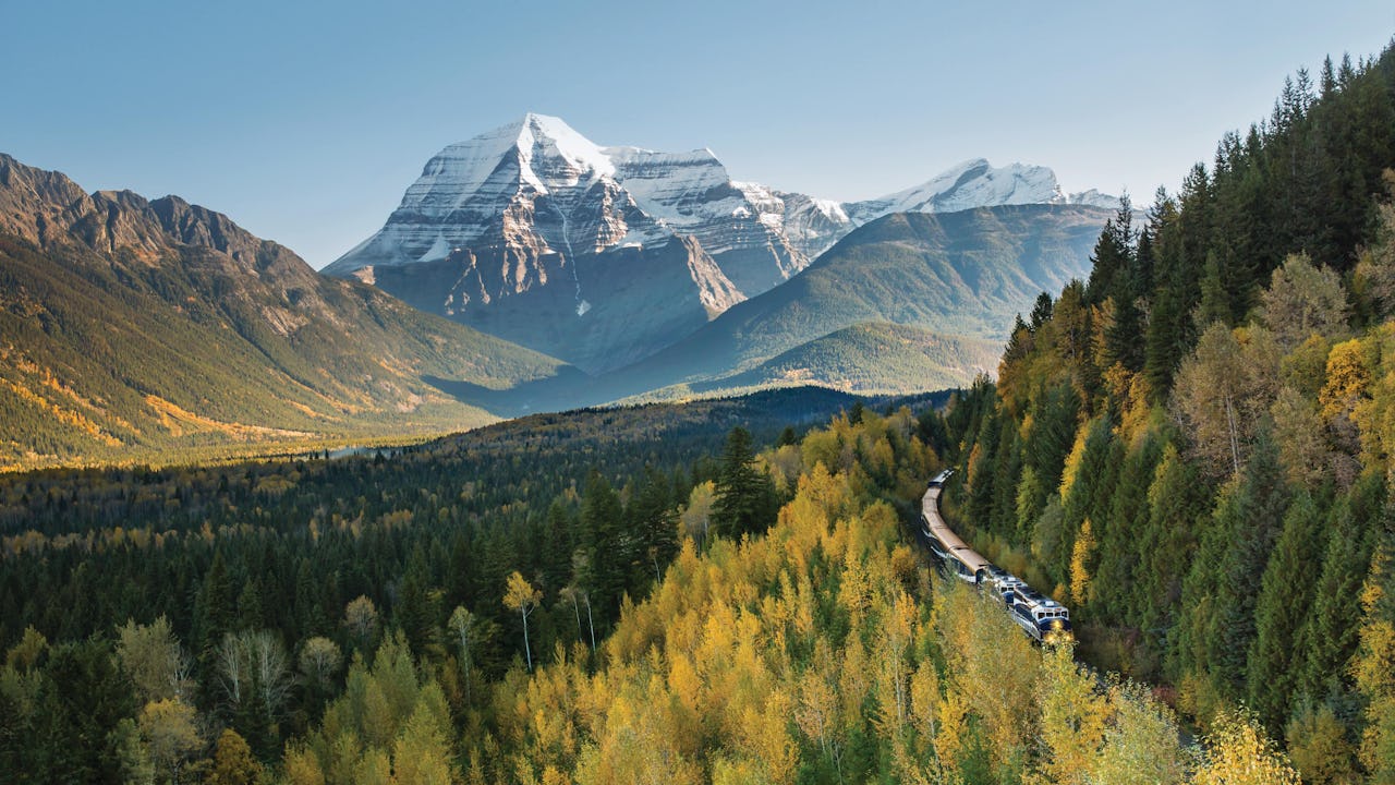 Rocky Mountaineer carving through lush forests and mountains
