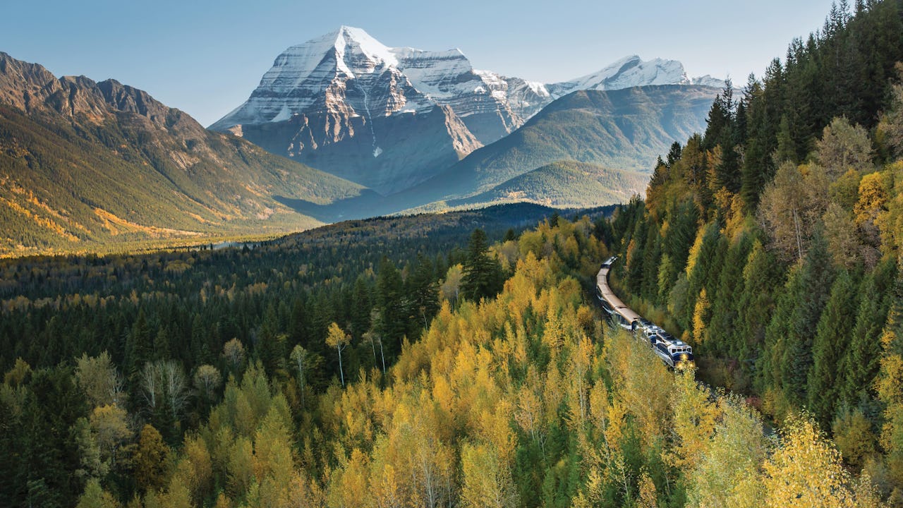 Rocky Mountaineer carving through lush forests and mountains