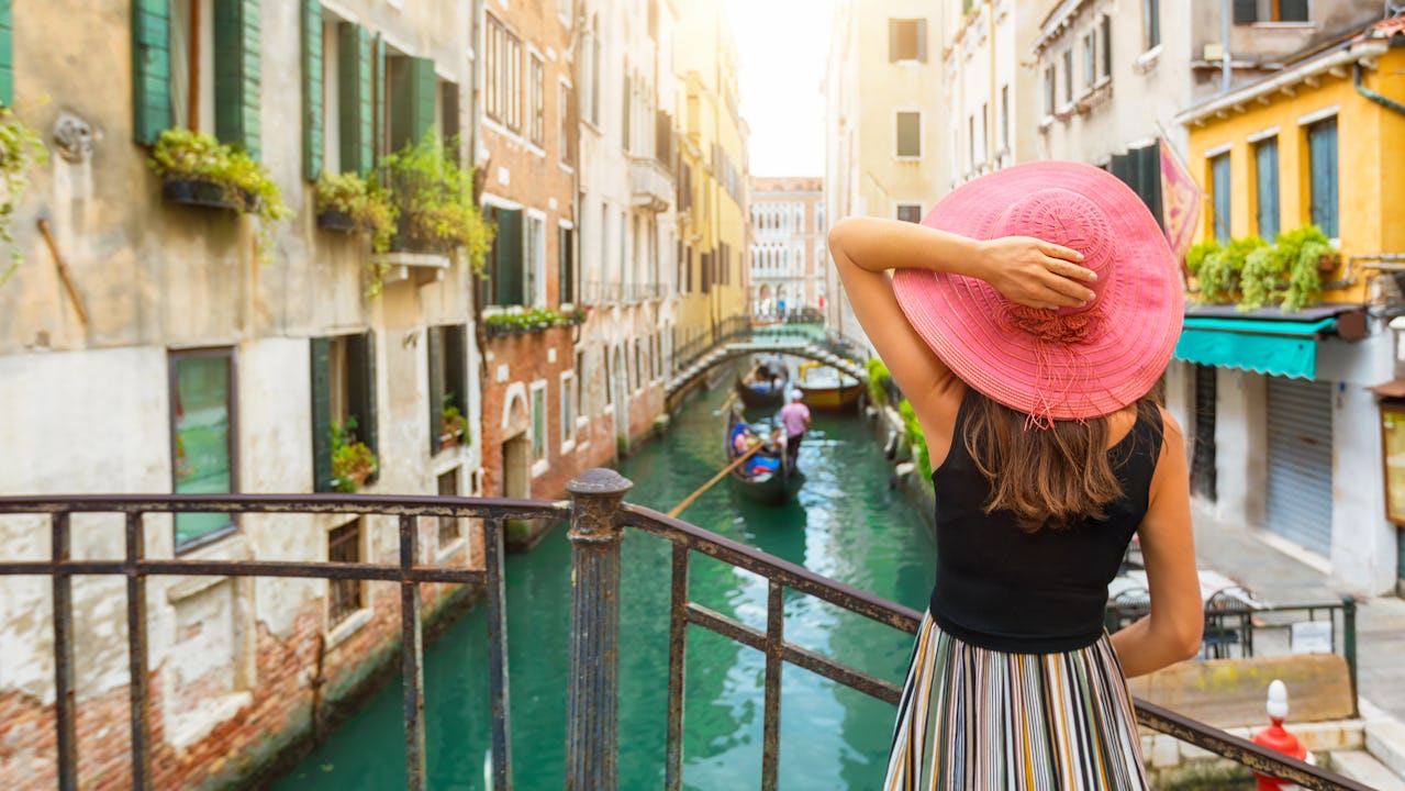 Woman enjoys the view to a canal in Venice